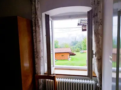 an open window with a view of a house at Casa Bruna by Go New Location in Varena