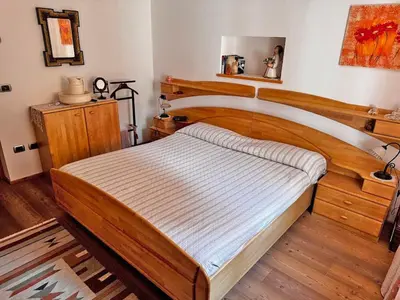 a kitchen with wooden cabinets and a table in it at Appartamento Town Center in Predazzo