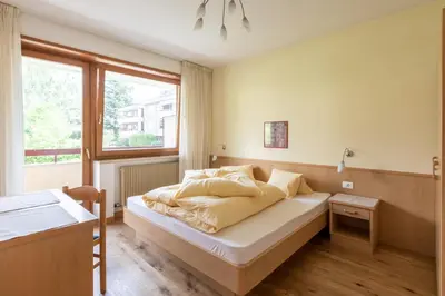 a bedroom with a bed and a window at Appartement Huber in Merano