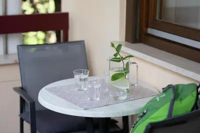 a white table with a vase and glasses on it at Appartement Huber in Merano