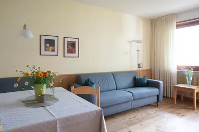 a living room with a blue couch and a table at Appartement Huber in Merano
