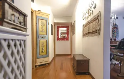 two views of a hallway of a home with a door at Casa Cristallo in Cortina dʼAmpezzo