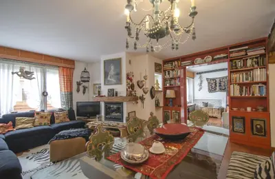 a living room with a couch and a chandelier at Casa Cristallo in Cortina dʼAmpezzo