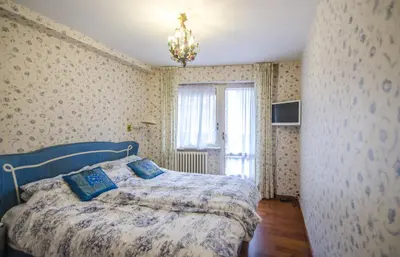 a bedroom with a bed in a room with wallpaper at Casa Cristallo in Cortina dʼAmpezzo