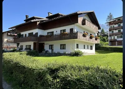 a large house with a balcony and a yard at Ca' del Ghiaccio in Cortina dʼAmpezzo