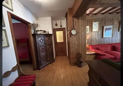a living room with a red couch and wooden walls at Ca' del Ghiaccio in Cortina dʼAmpezzo