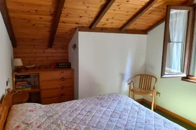 a bedroom with a bed and a wooden ceiling at Appartamento Magico Abete by Sunhome Fiemme in Bellamonte