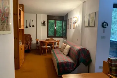 a living room with a table and a couch at Appartamento Magico Abete by Sunhome Fiemme in Bellamonte