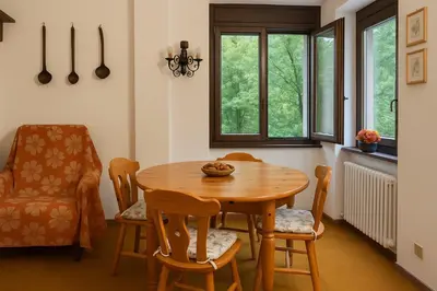 a dining room with a wooden table and chairs at Appartamento Magico Abete by Sunhome Fiemme in Bellamonte
