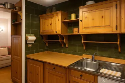 a kitchen with wooden cabinets and a sink at Appartamento Magico Abete by Sunhome Fiemme in Bellamonte