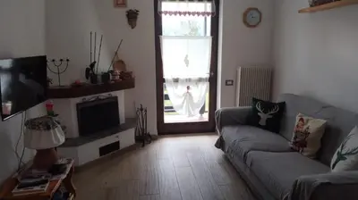 a living room with a couch and a television at Via Latemar - Villaggio Veronza in Carano
