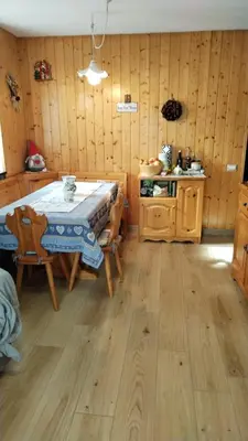 a dining room with a table and wooden walls at Via Latemar - Villaggio Veronza in Carano