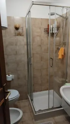 a bathroom with a shower with a toilet and a sink at Via Latemar - Villaggio Veronza in Carano