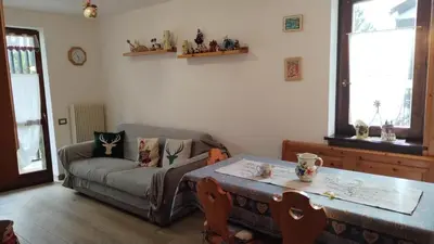 a living room with a couch and a table at Via Latemar - Villaggio Veronza in Carano
