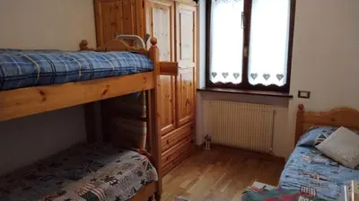 a bedroom with two bunk beds and a window at Via Latemar - Villaggio Veronza in Carano