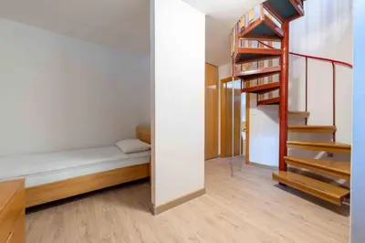 a small room with a bed and a staircase at Cesa Agnol in Mazzin