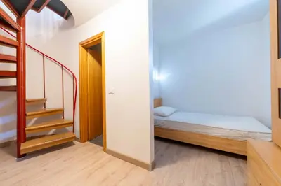 a small room with a bed and a staircase at Cesa Agnol in Mazzin