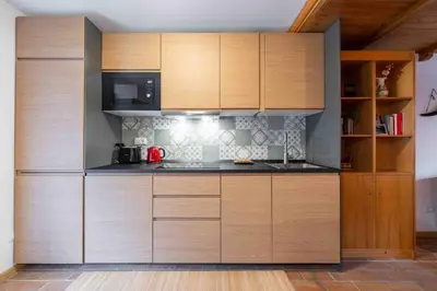 a kitchen with wooden cabinets and a microwave at Cesa Agnol in Mazzin