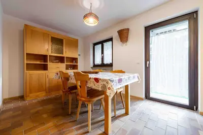 a dining room with a table and chairs and a window at Cesa Agnol in Mazzin