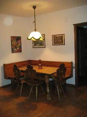 a dining room table with chairs and a light at Appartamento in chalet ampezzano in Alvera