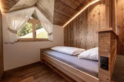 a bed in a room with a window at Dickerhof - Urlaub auf dem Bauernhof in San Genesio Atesino
