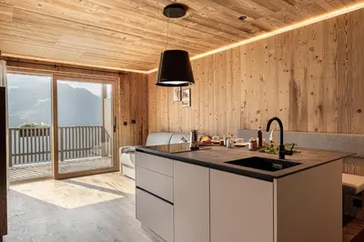 a kitchen with wooden walls and a counter with a sink at Dickerhof - Urlaub auf dem Bauernhof in San Genesio Atesino