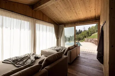 two beds in a room with a large window at Dickerhof - Urlaub auf dem Bauernhof in San Genesio Atesino
