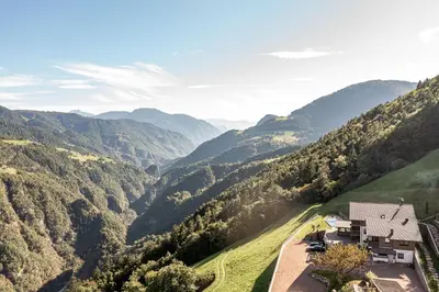 a house on a hill with a view of mountains at Dickerhof - Urlaub auf dem Bauernhof in San Genesio Atesino