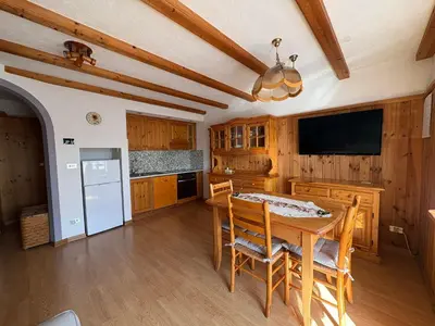 a kitchen with a wooden table and a television at Casa Girasole in Carano