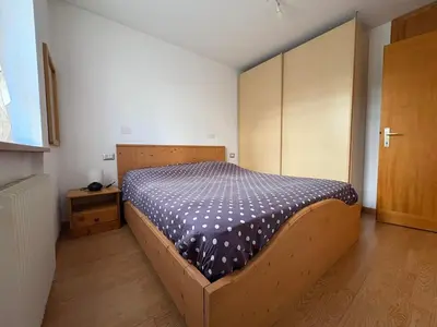 a bedroom with a bed with a wooden bed frame at Casa Girasole in Carano