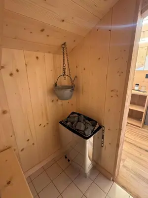 a small room in a wooden cabin with a bucket at Caluma El Paradis in Comune Rivamonte Agordino