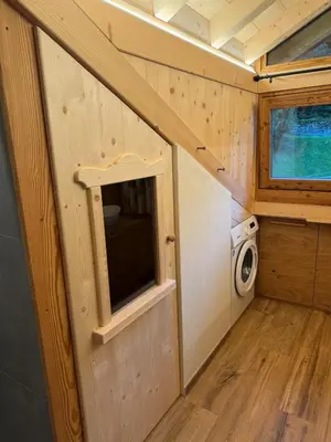 a tiny house with a window and a washing machine at Caluma El Paradis in Comune Rivamonte Agordino