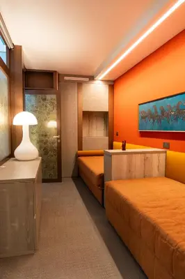 a hotel room with two beds and a lamp at Fienila Luxury Spa Cortina in Cortina dʼAmpezzo