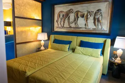 a bedroom with a bed with a painting on the wall at Fienila Luxury Spa Cortina in Cortina dʼAmpezzo