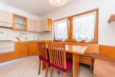 a kitchen with a wooden dining room table and chairs at Casa Sangi in Caviola