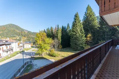 a balcony with a view of a street and trees at Casa Sangi in Caviola
