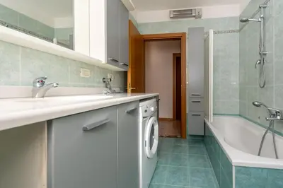 a bathroom with a sink and a washing machine at Casa Sangi in Caviola
