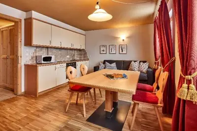 a kitchen and living room with a table and a couch at Residence Amonit in Corvara in Badia