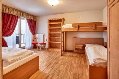 a bedroom with two bunk beds and a desk at Residence Amonit in Corvara in Badia