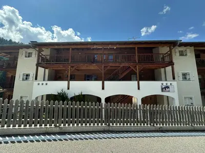 a building with a wooden fence in front of it at Residence Amonit in Corvara in Badia