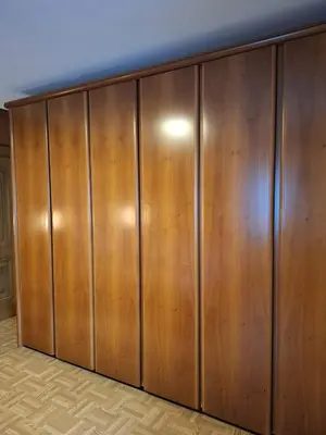 a closet with wooden doors in a room at Appartamenti - Sass de Stria Cernadoi Dolomiti in Andraz