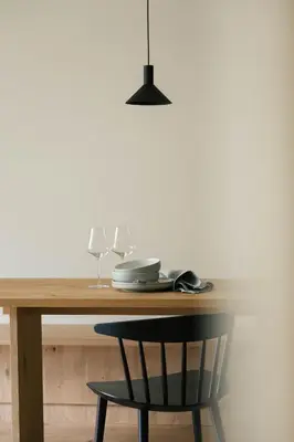 a wooden table with a black chair and a lamp at Apartment Garden Loggia in Novacella