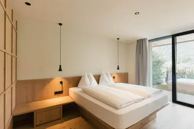 a bedroom with a large white bed and a window at Apartment Garden Loggia in Novacella