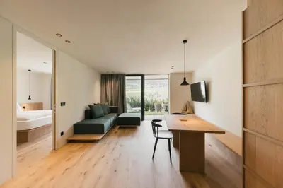 a small apartment with a desk and a bedroom at Apartment Garden Loggia in Novacella