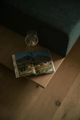a book sitting on the floor next to a glass at Apartment Garden Loggia in Novacella