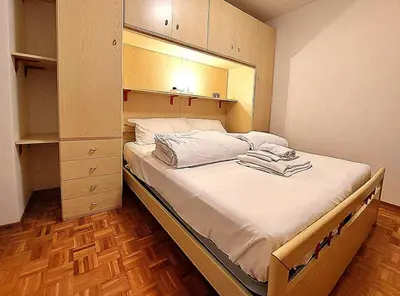 a bedroom with a large bed with a cabinet at Two-bedroom apartment-Casa Pieri in Penia