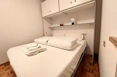 a small room with two beds with white sheets at Two-bedroom apartment-Casa Pieri in Penia