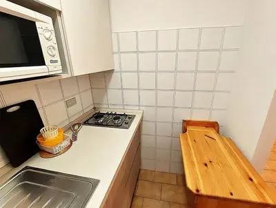 a small kitchen with a stove and a microwave at Two-bedroom apartment-Casa Pieri in Penia