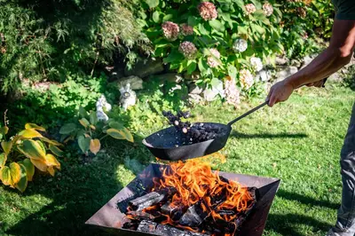 a person is stirring a pot on a grill at Niederhof - Urlaub auf dem Bauernhof in Brixen