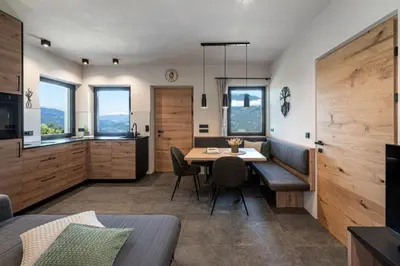 a room with a table and a kitchen with windows at Niederhof - Urlaub auf dem Bauernhof in Brixen